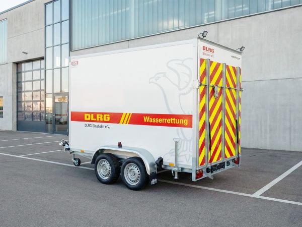 DLRG-Kofferanhängers mit der Aufschrift „Wasserrettung“ und auffälliger rot-gelber Heckwarnbeklebung