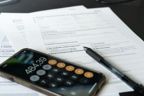 Angebots- und Kalkulationsunterlagen mit Taschenrechner und Stift