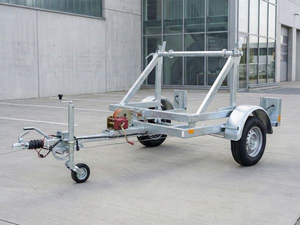 Kabeltrommelanhänger in stabiler Stahlrahmenbauweise mit integrierter Ladewelle und roter Handwinde für den effizienten Kabelleitungsbau