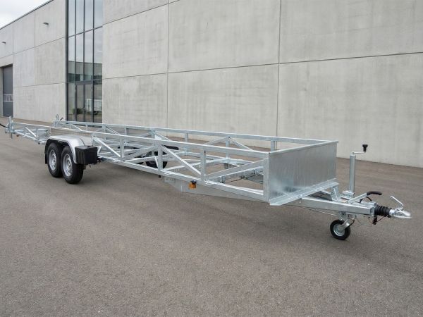 Spezialisierter Langgutanhänger mit stabiler Tandemachse, langer Deichsel und seitlichem Fachwerkträger-Rahmen aus verzinktem Stahl