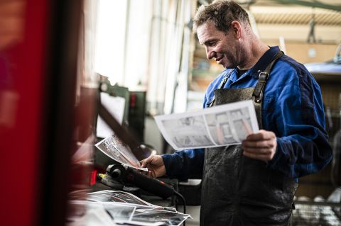 Ein Handwerker prüft eine technische Zeichnung für die Fertigung oder Montage