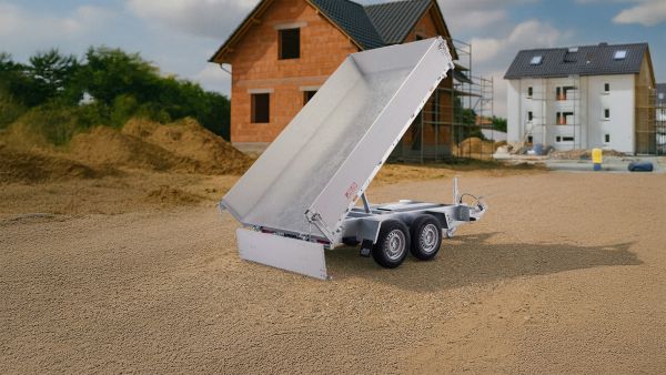 Dreiseitenkipper Anhänger auf Baustelle mit gekippter Ladefläche