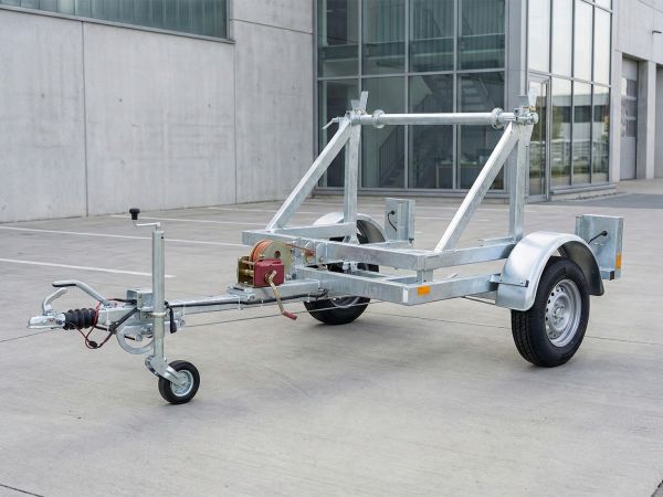 Kabeltrommelanhänger in stabiler Stahlrahmenbauweise mit integrierter Ladewelle und roter Handwinde für den effizienten Kabelleitungsbau