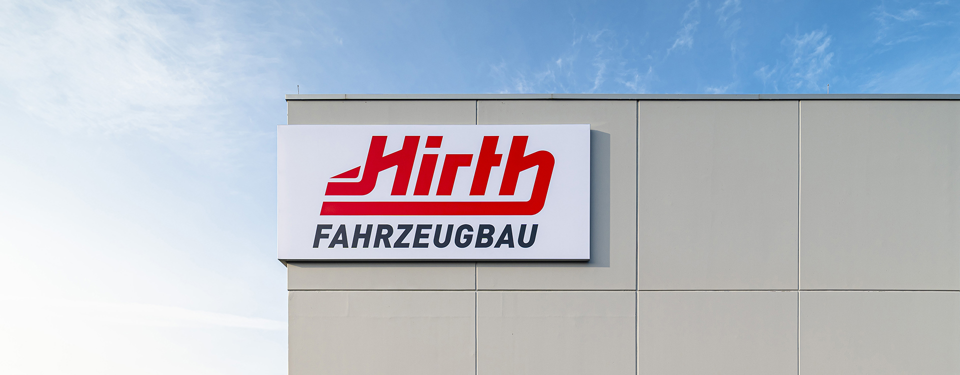 Schild mit Firmenlogo von Hirth Fahrzeugbau am Unternehmensgebäude